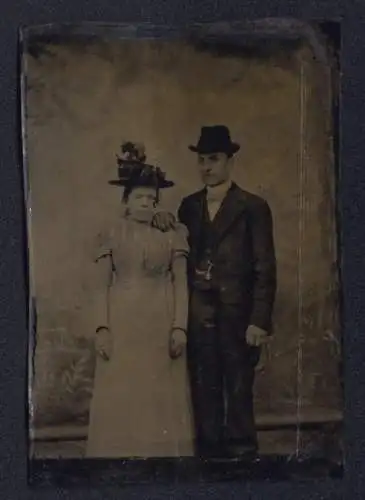 Fotografie Ferrotypie junges Paar im hellen Kleid mit Blumenhut und Herr im Anzug mit Fliege