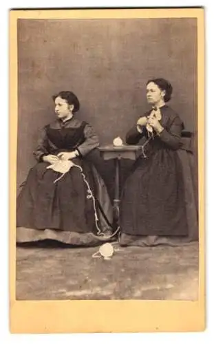 Fotografie unbekannter Fotograf und Ort, zwei Hausdamen beim Häkeln im Hausfrauenkleid mit Schürze, 1869