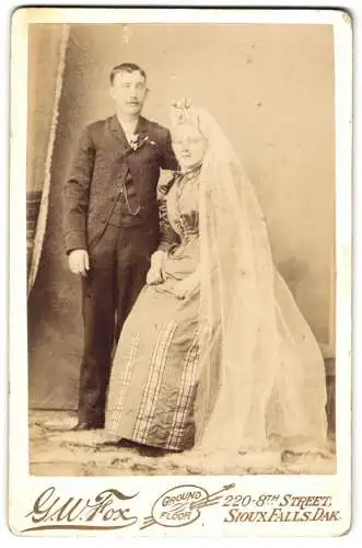 Fotografie G. W. Fox, Dioux Falls / SD, amerikanisches Ehepaar im Hochzeitskleid und im Anzug