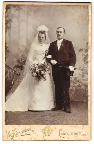 Fotografie M. Hirschbeck, Landsberg a. L., Eheleute im Hochzeitskleid und im Anzug mit Zylinder