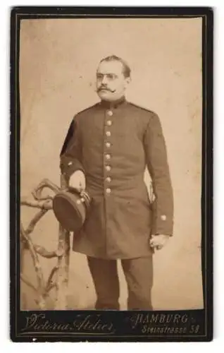 Fotografie Victoria Atelier, Hamburg, Steinstr. 58, Soldat mit Zwicker u. Schirmmütze in Uniform