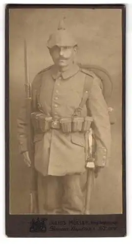 Fotografie Julius Müller, Dessau, Soldat in Feldgrau Uniform mit Pickelhaube Tarnbezug, Bajonett auf Gewehr, Ausmarsch