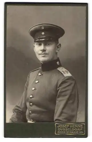 Fotografie Josef Henne, Düsseldorf, Ross-Str. 65, Lächelnder Soldat Rgt. 39 in Uniform mit Schirmmütze