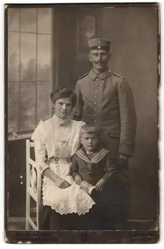 Fotografie Wilhelm Loos, Augustusburg i. Erzgb., Marienbergerstr. 25, Soldat in Uniform mit Krätzchen, Frau u. Kind