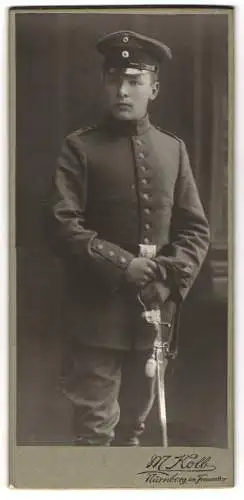 Fotografie M. Kolb, Nürnberg, im Frauentor, Junger Soldat Rgt. 14 in Uniform mit Schirmmütze u. Säbel