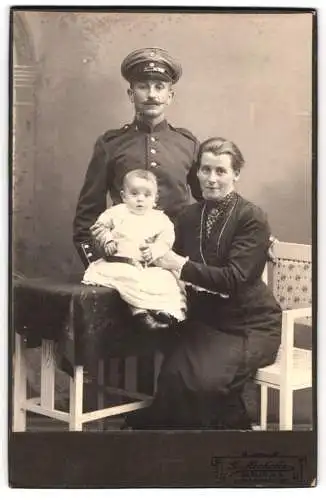 Fotografie G. Michelis, Berlin, Chausseestr. 102, Soldat Rgt. 64 in Uniform mit Schirmmütze, Ehefrau u. Kind