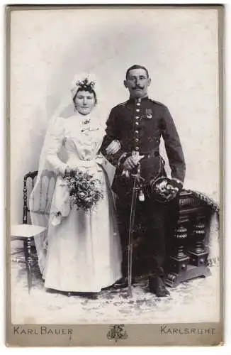 Fotografie Karl Bauer, Karlsruhe, badischer Uffz. in Uniform mit Artillerie Pickelhaube und Orden, Braut, Kriegshochzeit