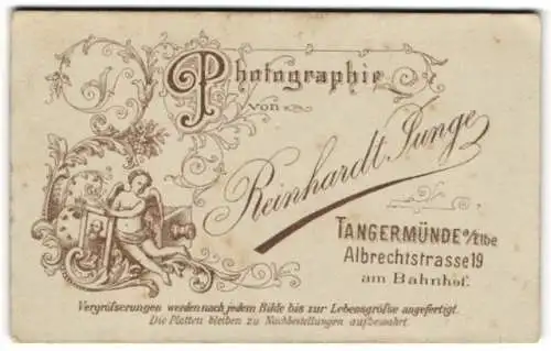 Fotografie Reinhardt Junge, Tangermünde a. Elbe, Albrechtstr. 19, kleiner Engel mit Plattenkamera, florale Verzierung