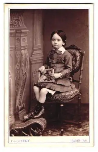 Fotografie F. L. Giffey, Hamburg, junges schwarzhaariges Mädchen posiert mit Märchenbuch auf dem Schoss
