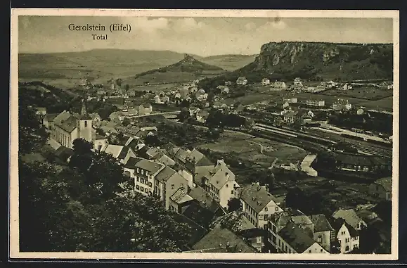 AK Gerolstein /Eifel, Ortsansicht mit Kirche und umliegendem Felsmassiv