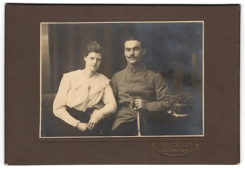 Fotografie Carl Huth, Lüdenscheid, Uffz. in Uniform Feldgrau mit Säbel neben Ehefrau