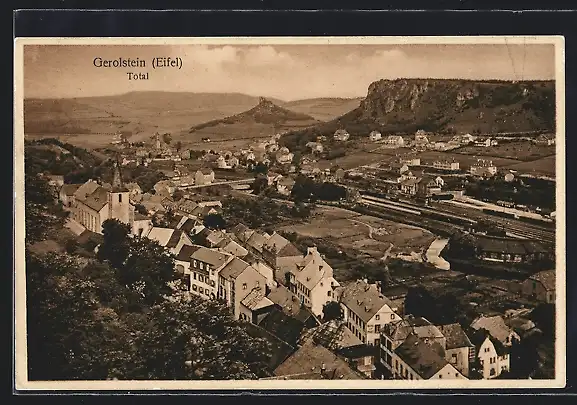 AK Gerolstein /Eifel, Ortsansicht mit Kirche und umliegendem Felsmassiv