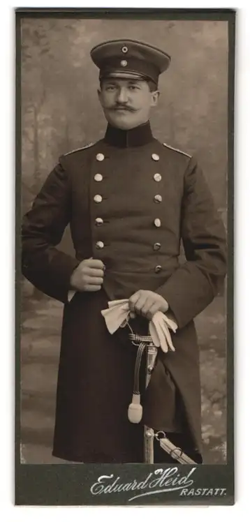 Fotografie Eduard Heid, Rastatt, Kriegstr.19, Soldat in Uniform mit Degen und Schirmmütze, 1905