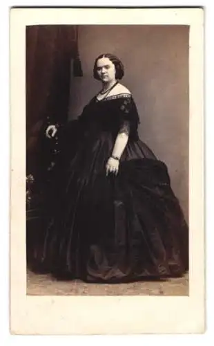 Fotografie C. Schwartz & Co., Berlin, korpulente Dame im schwarzen schulterfreien Kleid mit Perlenkette