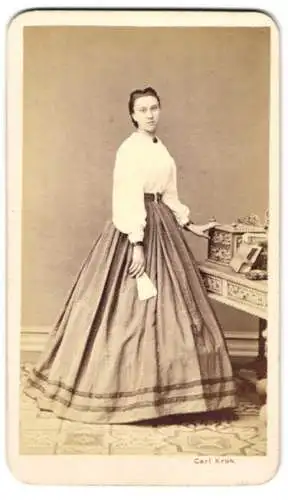 Fotografie Carl Kroh, Wien-Josefstadt, Piaristengasse 20, junge Dame in heller Bluse mit Reifrockkleid am Sekretär