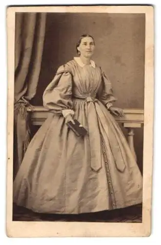 Fotografie J. C. Wolff, Wien, Dame im hellen weiten Kleid mit Album in der Hand