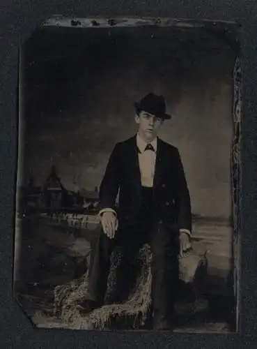 Fotografie Ferrotypie junger Mann im dunklen Anzug mit Siegelring am Finger vor einer Studiokulisse