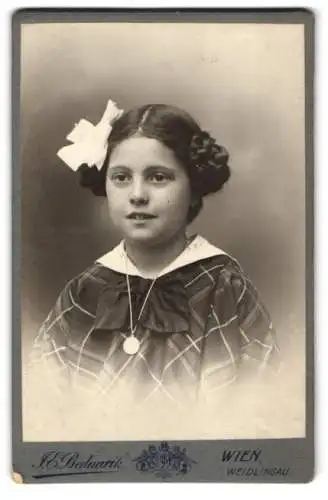 Fotografie J. E. Bednarik, Wien, junges Mädchen mit Zöpfen und Haarschleife