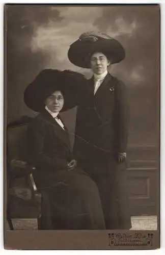 Fotografie Walter Klie, Göttingen, zwei Damen in dunklen Kleidern mit breitem Federhut