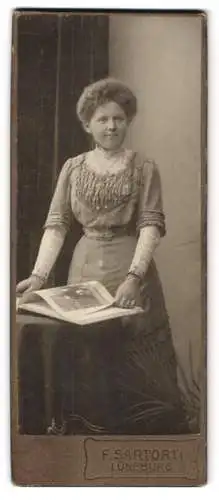 Fotografie F. Sartorti, Lüneburg, Hübsche Frau mit krausem Haar blättert in einem Buch
