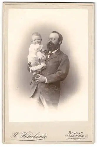 Fotografie H. Haberlandt, Berlin, Anhalt-Str. 2, Vater mit Vollbart u. Kneifer hält glückliches Kleinkind im Arm
