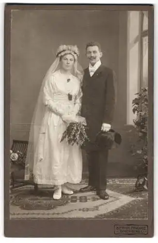 Fotografie Bernh. Franke, Spremberg, Hübsche Braut m. Kopfschmuck u. Schleier im Hochzeitskleid, Brautpaar