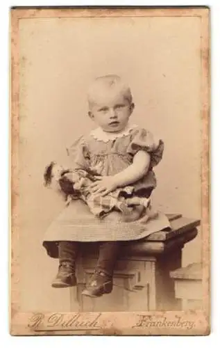 Fotografie R. Dittrich, Frankenberg, Freibergerstr. 33, Kleinkind m. kurzen Haaren im Rüschenkleid mit Puppe