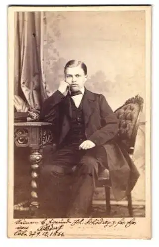 Fotografie W. Mayr, Kreuznach, junger Mann Herr Polsdorf im Anzug mit Fliege, sitzend am Sekretär, 1866