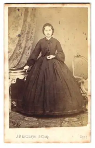 Fotografie J. B. Rottmayer & Comp., Graz, junge Frau im schwarzen Reifrock-Kleid mit Haube