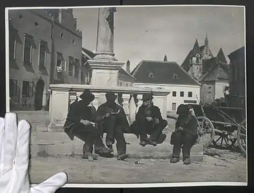 Fotografie unbekannter Fotograf, Ansicht Eggenburg N.Ö., Wanderprediger rasten an der Mariensäule im Ort, 40 x 30cm