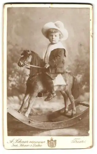 Fotografie A. Schaar, Trier, kleines Kind posiert auf seinem Schaukelpferd im Atelier