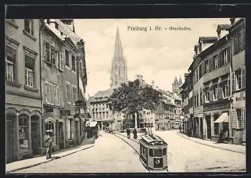 AK Freiburg i. Br., Oberlinden, Strassenpartie mit Strassenbahn und Kirche