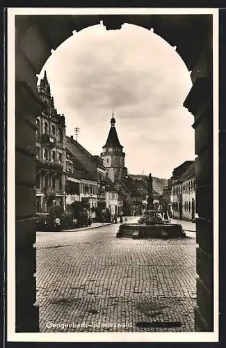 AK Gengenbach /Schwarzwald, Strassenpartie mit Geschäften und Brunnen durch Tor
