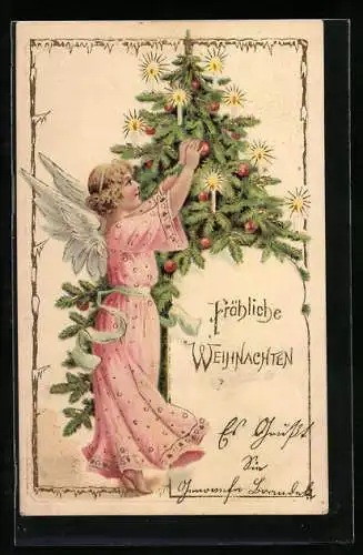 Präge-AK Weihnachtsengel schmückt einen Tannenbaum mit Kerzen und Kugeln