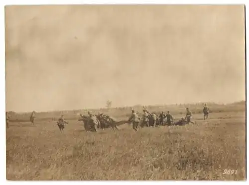 Fotografie 1.WK, Artilleristen mit Feldgeschütz beim Stellungswechsel auf dem Schlachtfeld