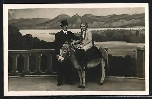 Foto-AK Vater neben seiner Tochter auf einem Esel vor einer Bergsee-Studiokulisse