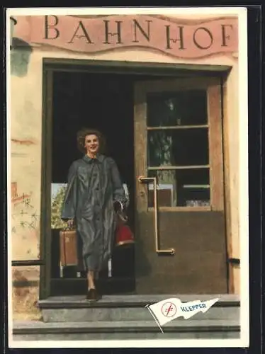 AK Reklame Klepperwerke, Junge Dame im Klepper-Mantel vor einem Bahnhof