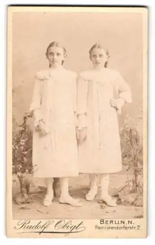 Fotografie Rudolf Obigt, Berlin, zwie junge Zwillings Mädchen in weissen Kleidern