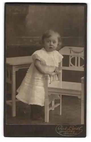 Fotografie Ant. Lintl, Gevelsberg, Kölnerstr. 68, Kleines Mädchen mit neugierigem Blick im weissen Kleid