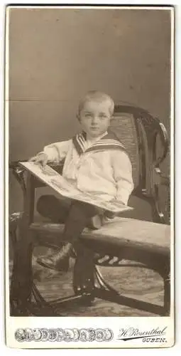 Fotografie H. Rosenthal, Guben, Kleiner Junge im Matrosenhemd mit einem Bilderbuch auf dem Schoss