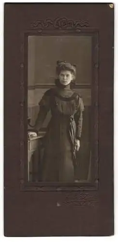 Fotografie Gebr. Thiele, Lehe a. W., Jugendliches Mädchen im eleganten schwarzen Kleid mit samtenem Hüftband