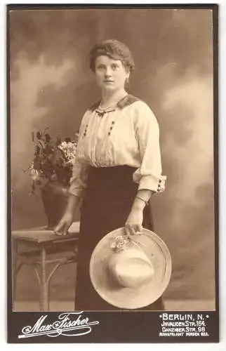Fotografie Max Fischer, Berlin, Invalidenstr. 164, Junge Frau in weisser Bluse und schwarzem Rock mit einem Strohhut