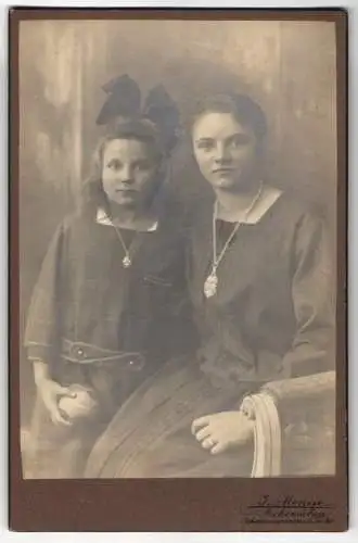 Fotografie J. Menge, Aschersleben, Johannespromenade 20, Ein jugendliches Mädchen mit ihrer kleinen Schwester