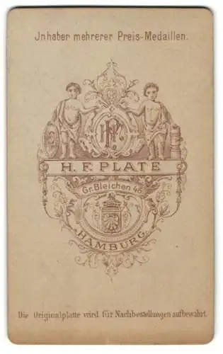 Fotografie H. F. Plate, Hamburg, zwei Jünglinge halten ein Wappenschild mit Monogram des Fotografen
