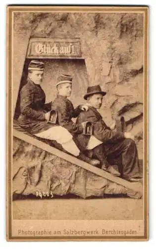 Fotografie P. Ney, Berchtesgaden, Besucher als Bergleute / Kumpel in einer Studiokulisse mit Gruben-Lampen