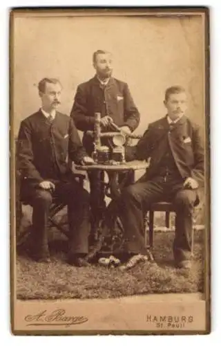 Fotografie A. Barge, Hamburg, drei Herren beim Schwarzbier trinken im Atelier, gesellige Runde