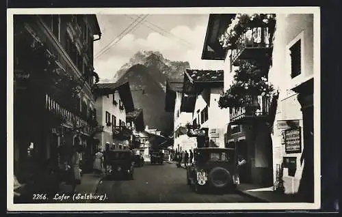 AK Lofer, Teilansicht mit Tabakwaren und Automobilen, Blick auf Berg