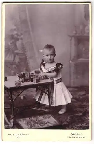 Fotografie Atelier Schmid, Altona, Königstr. 178, Kleines Kind im Kleid spielt mit Würfeln