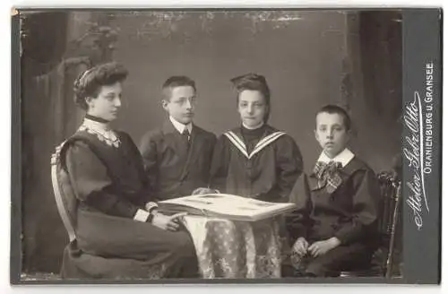 Fotografie Atelier Gebr. Otto, Oranienburg, Junge Dame im Kleid mit drei Kindern