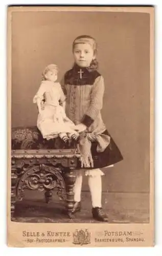 Fotografie Selle & Kuntze, Potsdam, junges Mädchen im Kleid präsentiert ihrer grosse Puppe